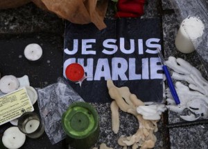 Photo of candles and a "Je Suis Charlie" banner arrange as a memorial