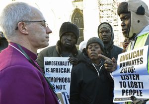 The Archbishop of Canterbury Justin Welby (L) speaks with protestors in the grounds of Canterbury Cathedral in Canterbury, southern Britain January 15, 2016. The Anglican Church has slapped sanctions on its liberal U.S. branch for supporting same-sex marriage, a move that averted a formal schism in the world's third largest Christian denomination but left deep divisions unresolved. The Anglican communion, which counts some 85 million members in 165 countries, has been in crisis since 2003 because of arguments over sexuality and gender between liberal churches in the West and their conservative counterparts, mostly in Africa. REUTERS/Toby Melville - RTX22JZ6