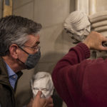 carving of elie weisel being installed on cathedral doorway