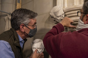 carving of elie weisel being installed on cathedral doorway